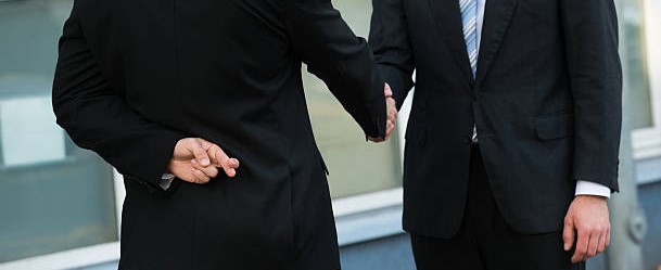 Shaking hands while fingers crossed behind back.